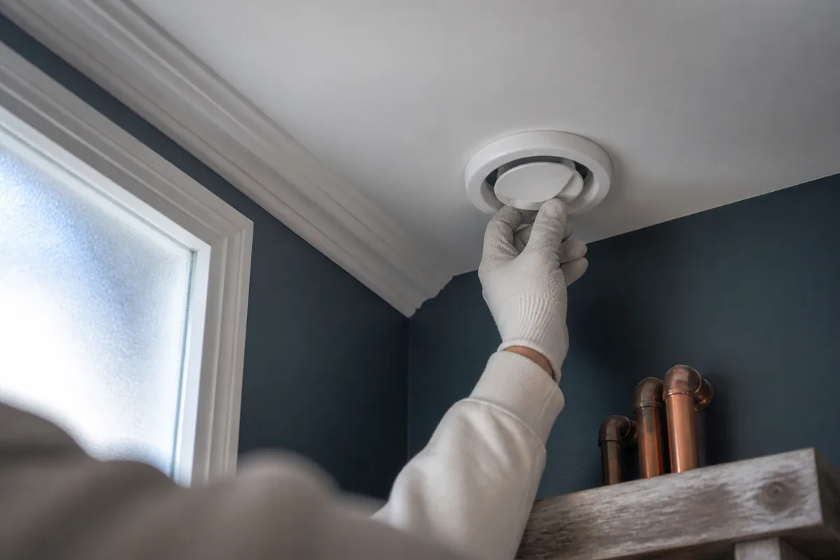 Bouche de ventilation hygroréglable au plafond d&rsquo;une salle d&rsquo;eau claire après rénovation